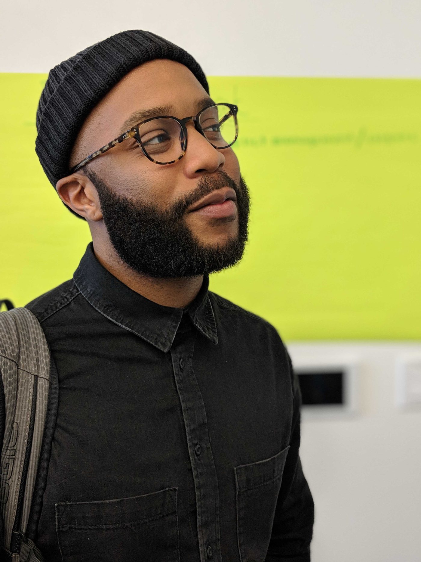 Brian Garrett, wearing a beanie and glasses, looking off to the side